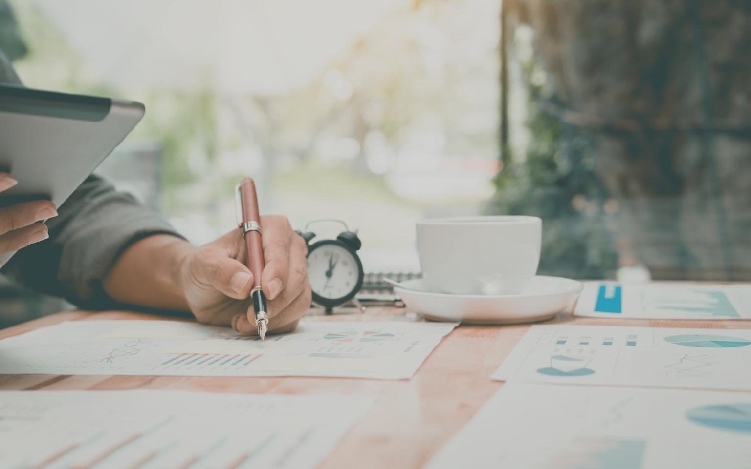 Pessoa a organizar categorias de orçamento numa mesa de trabalho